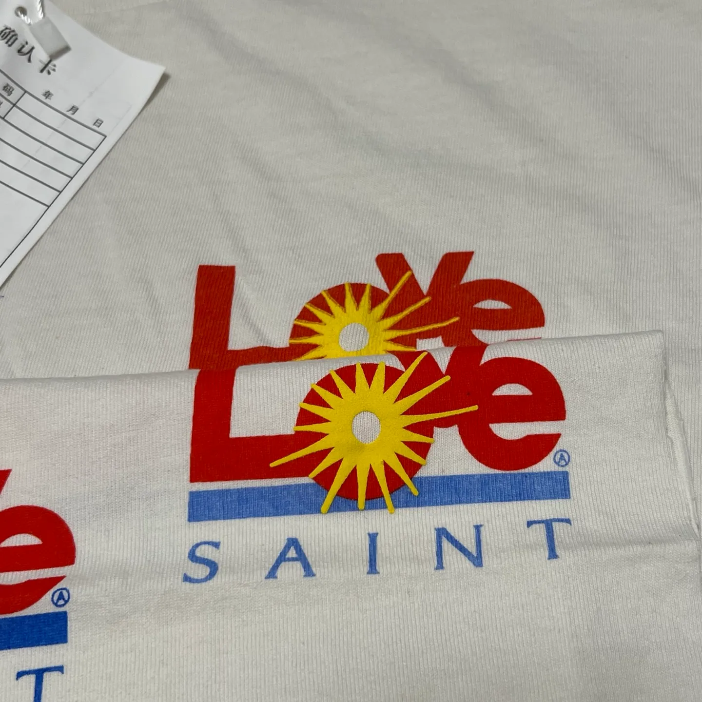 Printing and proofing comparison SAINT Mxxxxxx 25SS LOVE_SS TEE/WHT LOVE little sun damaged washed distressed short sleeves off-white S-XL rainbow OE yarn original consistent tube woven side seam fabric re-washed distressed process cut and destroyed holes processing hand-made graffiti splash ink original consistent main mark/wash mark/little angel anti-counterfeiting mark